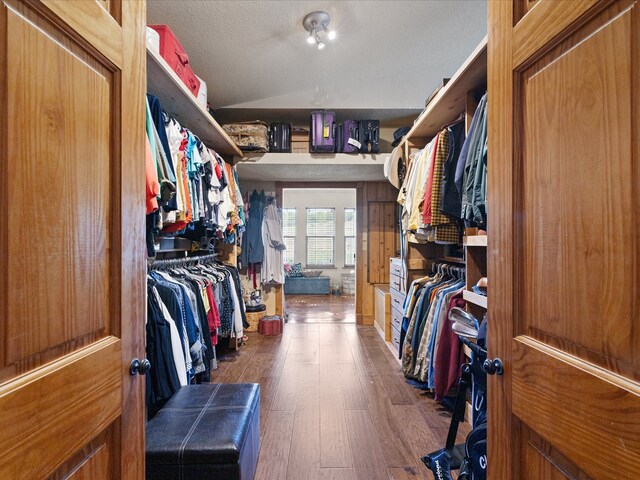 spacious closet featuring lofted ceiling and dark hardwood / wood-style flooring