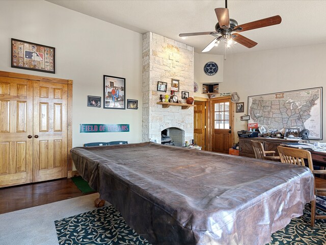 playroom with ceiling fan, a stone fireplace, pool table, and wood-type flooring