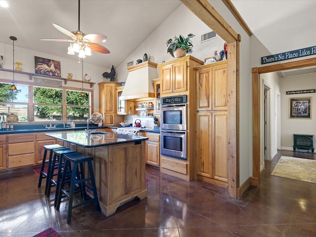 kitchen featuring sink, lofted ceiling, a kitchen breakfast bar, stainless steel appliances, and a center island with sink