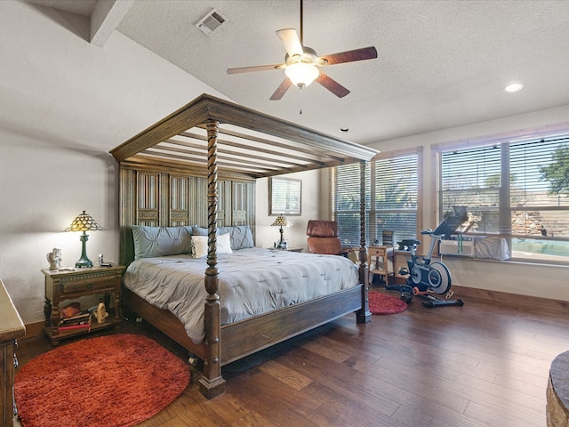 bedroom featuring a textured ceiling, beam ceiling, dark wood-type flooring, and ceiling fan