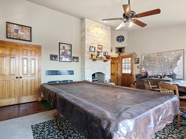 playroom with pool table, a stone fireplace, ceiling fan, and hardwood / wood-style flooring