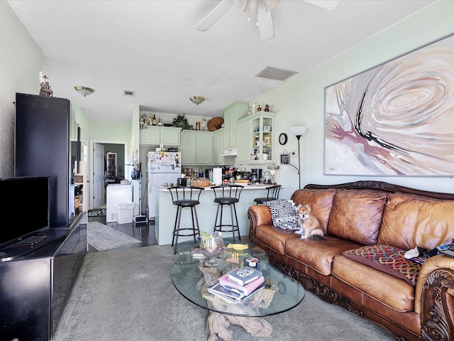 carpeted living room with ceiling fan