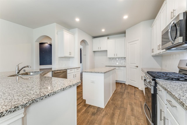 kitchen featuring sink, white cabinetry, appliances with stainless steel finishes, and a center island