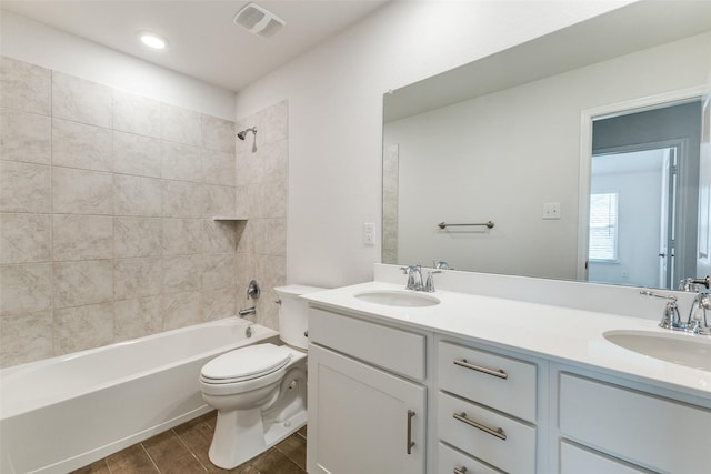 full bathroom with toilet, tiled shower / bath, and vanity