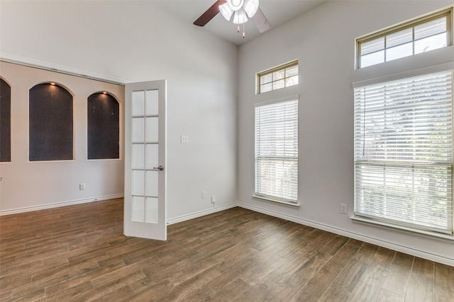 empty room with ceiling fan, dark wood-type flooring, and french doors