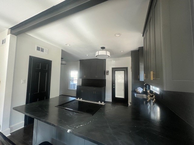 kitchen featuring kitchen peninsula, cooktop, gray cabinets, and sink