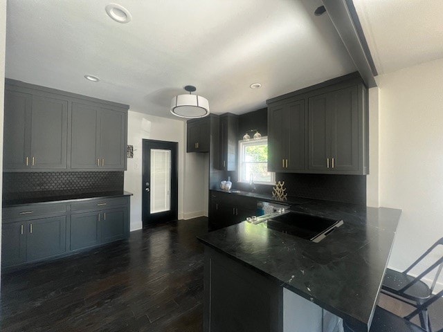 kitchen featuring gray cabinets, dark hardwood / wood-style flooring, and kitchen peninsula