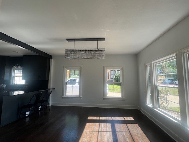 dining space with dark hardwood / wood-style flooring and a notable chandelier