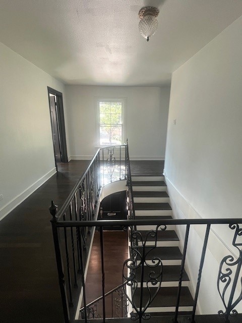 stairs with hardwood / wood-style flooring and a textured ceiling