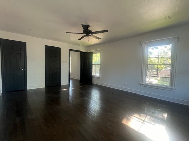 unfurnished bedroom with ceiling fan and dark wood-type flooring