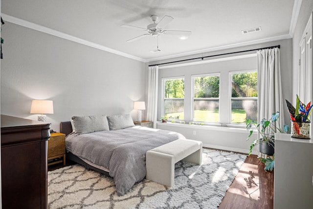 bedroom featuring ceiling fan, light wood-type flooring, and ornamental molding