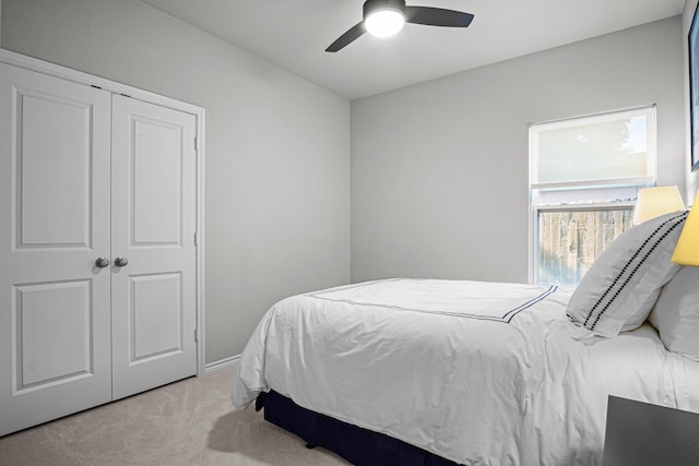 bedroom featuring ceiling fan, a closet, and light carpet