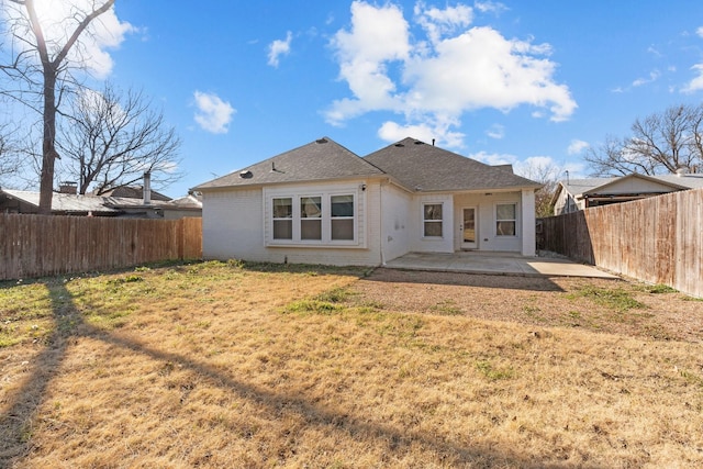 back of house with a patio and a lawn