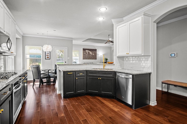 kitchen featuring sink, white cabinets, pendant lighting, crown molding, and appliances with stainless steel finishes