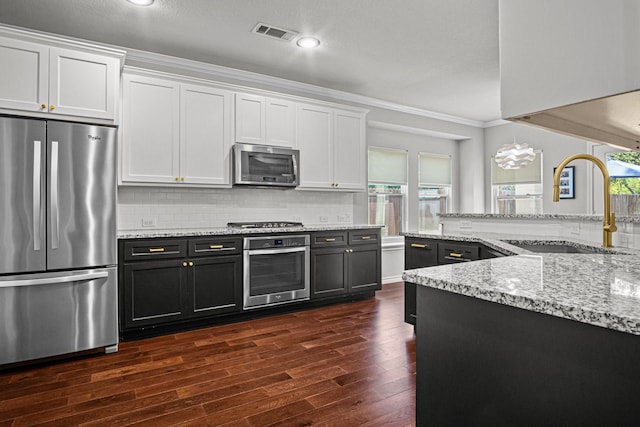 kitchen featuring sink, white cabinetry, dark hardwood / wood-style flooring, crown molding, and appliances with stainless steel finishes