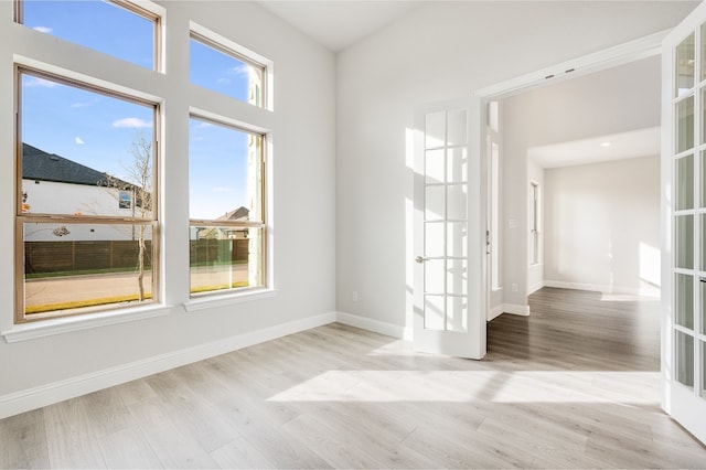 spare room with light hardwood / wood-style flooring and french doors