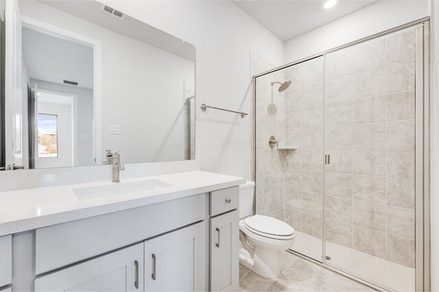 bathroom with vanity, toilet, and a shower with shower door