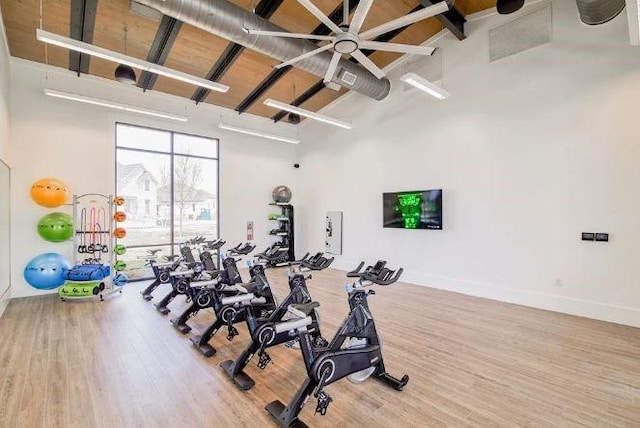 workout area featuring hardwood / wood-style floors and a high ceiling