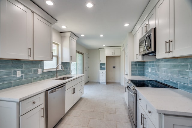 kitchen featuring stainless steel appliances, white cabinetry, sink, and light tile patterned floors