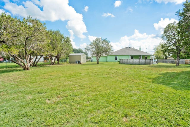 view of yard with a shed, an outdoor structure, and fence