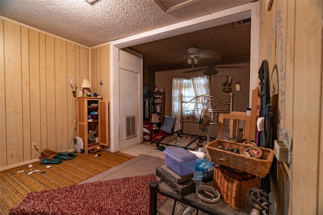 interior space with carpet, wooden walls, and a textured ceiling