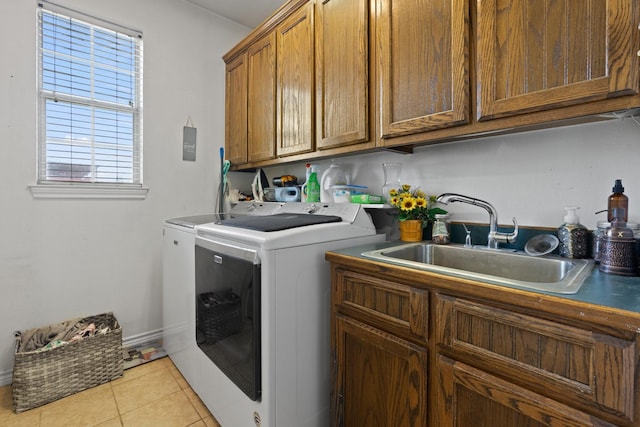 laundry room featuring light tile patterned flooring, cabinets, sink, and washing machine and clothes dryer