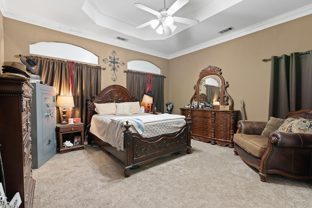 bedroom with a raised ceiling, ceiling fan, light carpet, and ornamental molding