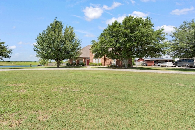 view of front of house featuring a front lawn and a water view