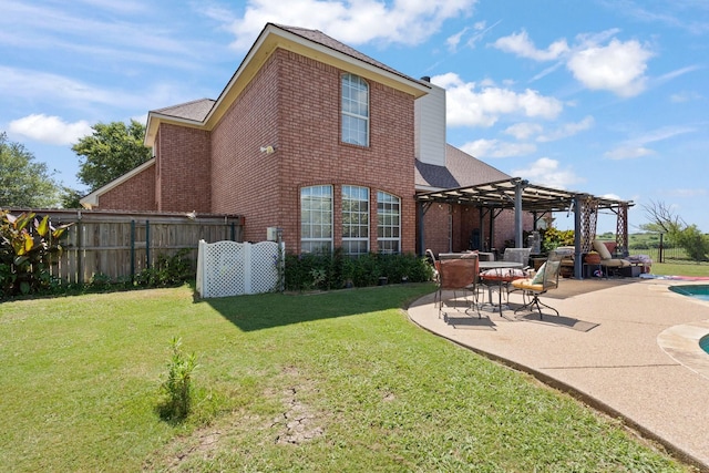 rear view of property with a yard, a pergola, and a patio area