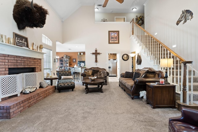 carpeted living room featuring ceiling fan, a towering ceiling, and ornamental molding