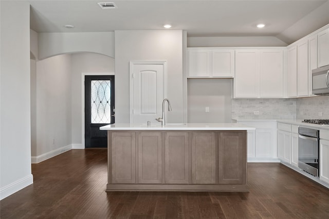 kitchen with sink, appliances with stainless steel finishes, an island with sink, and white cabinetry