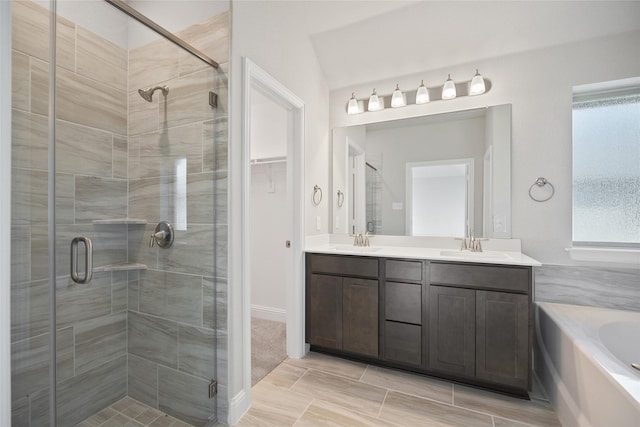 bathroom with plus walk in shower, a wealth of natural light, lofted ceiling, and vanity