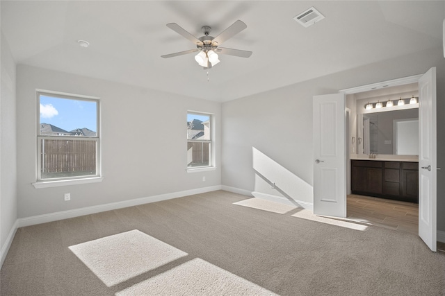 carpeted empty room featuring ceiling fan and plenty of natural light