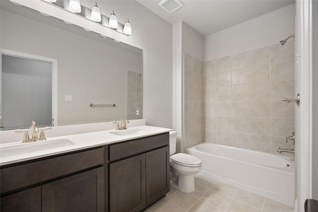 full bathroom featuring toilet, tiled shower / bath combo, tile patterned floors, and vanity