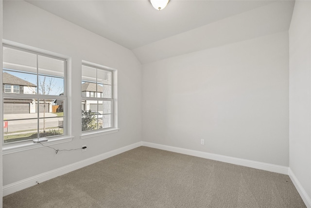 carpeted spare room featuring lofted ceiling