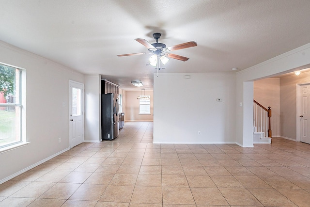 tiled empty room with ceiling fan and crown molding