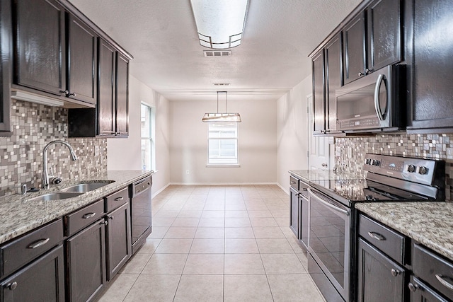 kitchen with light stone counters, sink, decorative light fixtures, and appliances with stainless steel finishes