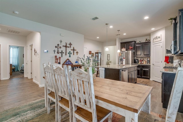 dining space with sink and light hardwood / wood-style floors