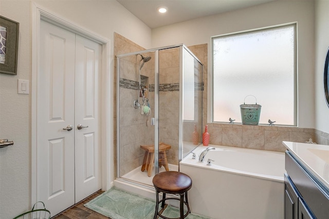 bathroom featuring vanity, a wealth of natural light, wood-type flooring, and independent shower and bath