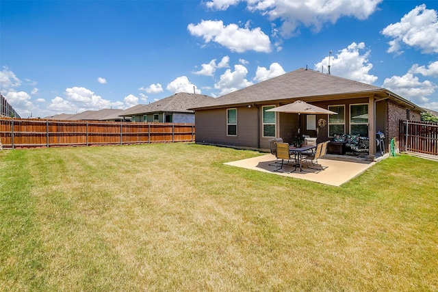 back of house with a lawn and a patio