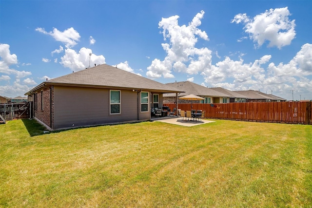 rear view of house featuring a lawn and a patio