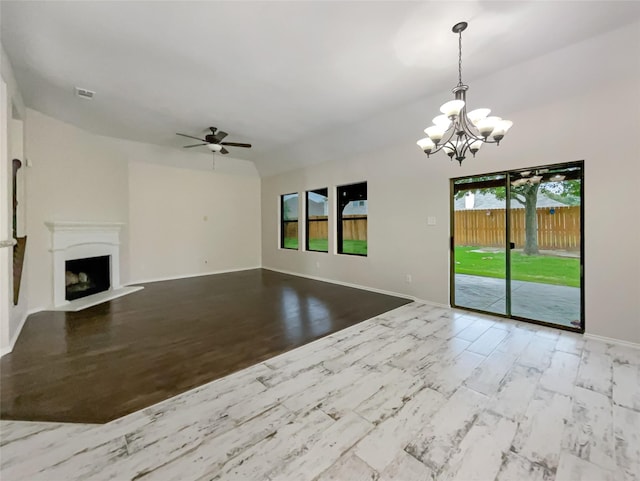 unfurnished living room with ceiling fan with notable chandelier, light hardwood / wood-style flooring, and a wealth of natural light