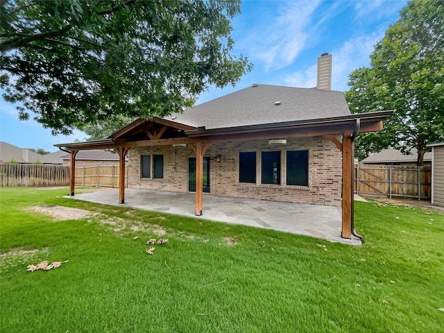 back of house with a yard and a patio