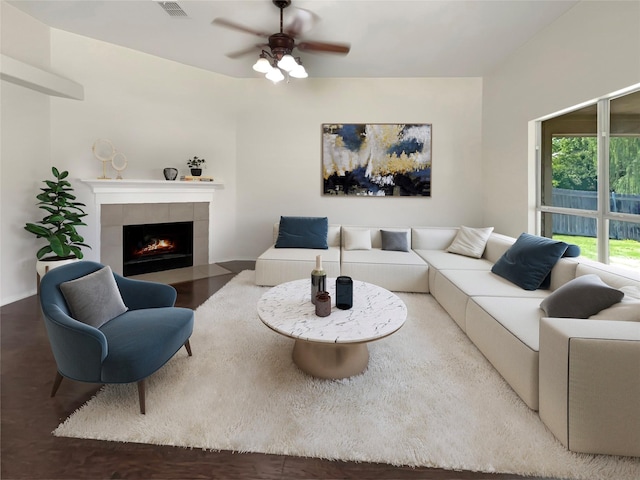 living room with a tile fireplace, hardwood / wood-style flooring, and ceiling fan