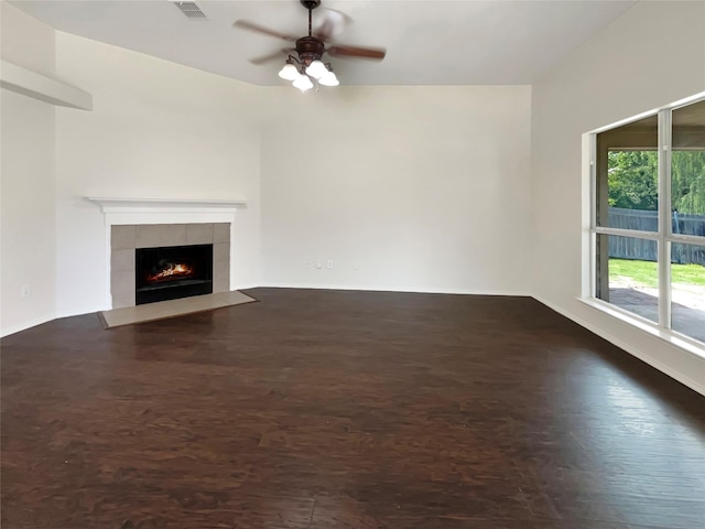 unfurnished living room featuring ceiling fan, dark hardwood / wood-style floors, and a fireplace