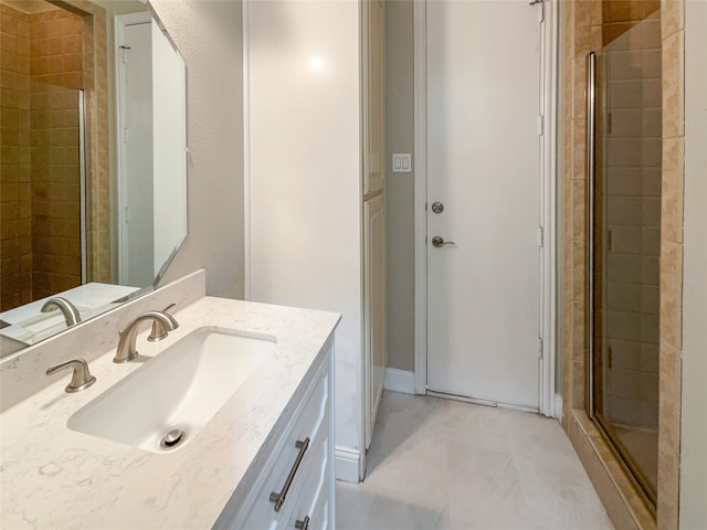 bathroom with a shower with shower door and vanity