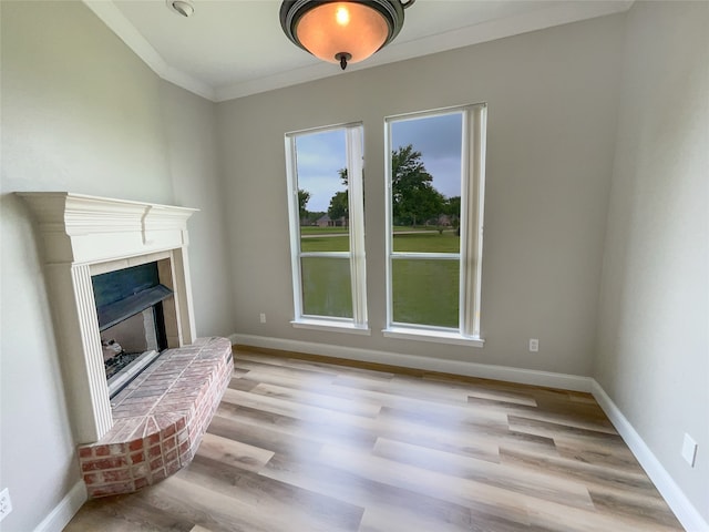 unfurnished living room with a brick fireplace, light hardwood / wood-style flooring, and ornamental molding