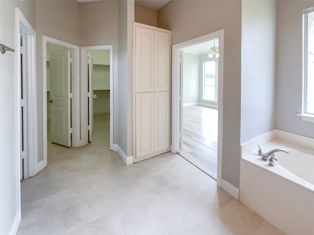 bathroom with ceiling fan and a bathtub