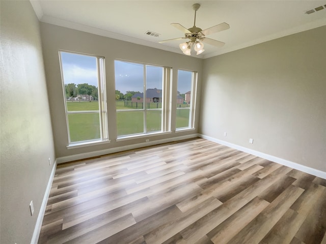 spare room featuring light wood-type flooring, ornamental molding, and ceiling fan