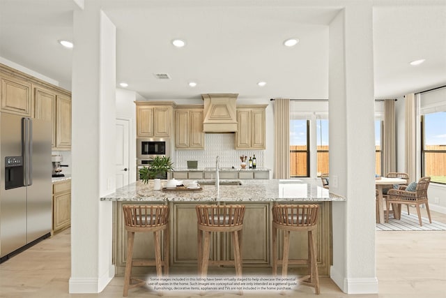 kitchen with stainless steel appliances, a breakfast bar, light wood-type flooring, and custom exhaust hood